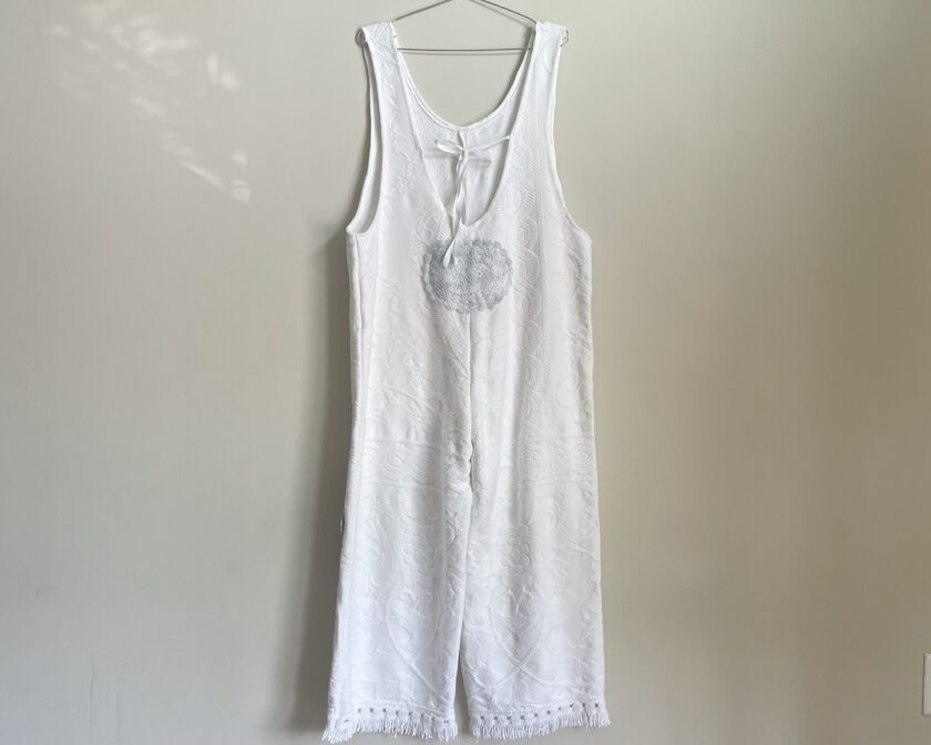 a white tank top hanging on a wall.