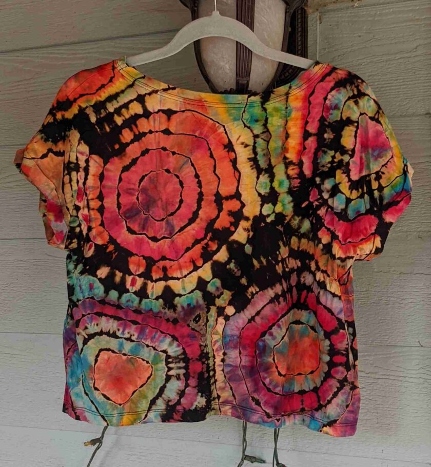 a colorful shirt is hanging on a hanger.