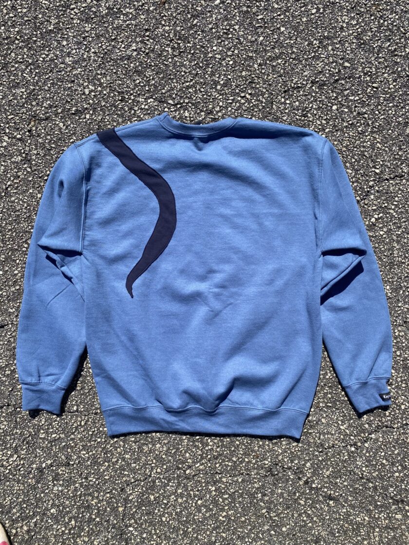 a blue sweatshirt laying on the ground.