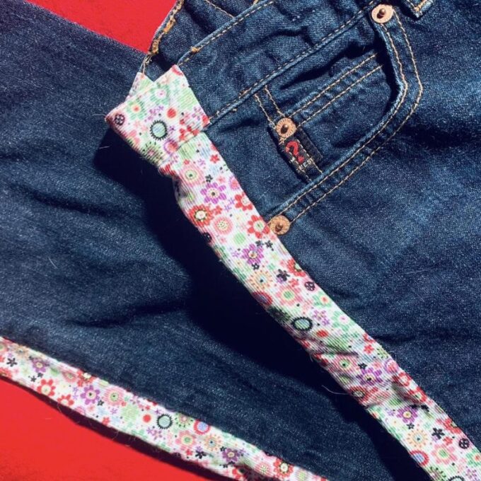 a pair of jeans laying on top of each other.