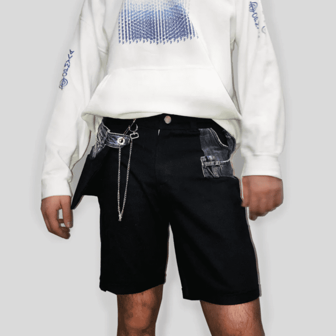 a man wearing a white sweatshirt and Bull Denim Up-worked Shorts in black.
