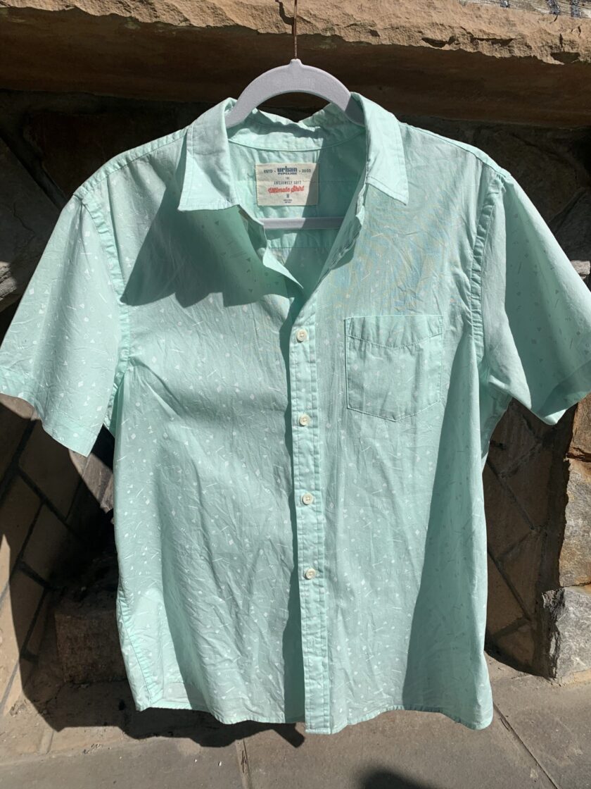 a light green shirt hanging on a clothes line.