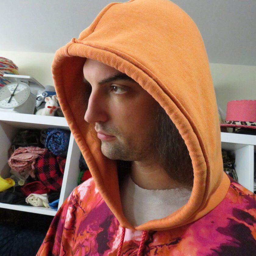 A man wearing a Marbled Orange Hoodie (X-Large) in a room.