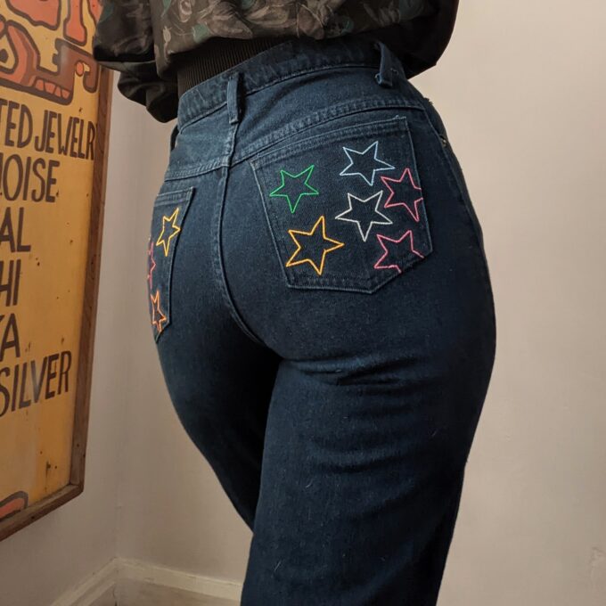 A woman wearing Reworked Embroidered Rainbow Star Pocket Jeans.