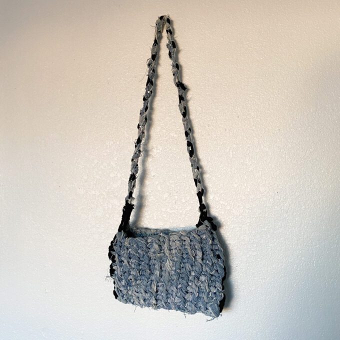 A 1of1 knotty bag hanging on a wall.