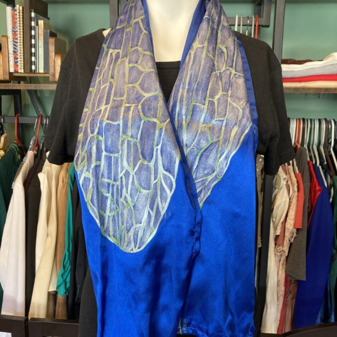 A mannequin wearing a hand-painted iridescent blue dragonfly wing scarf.