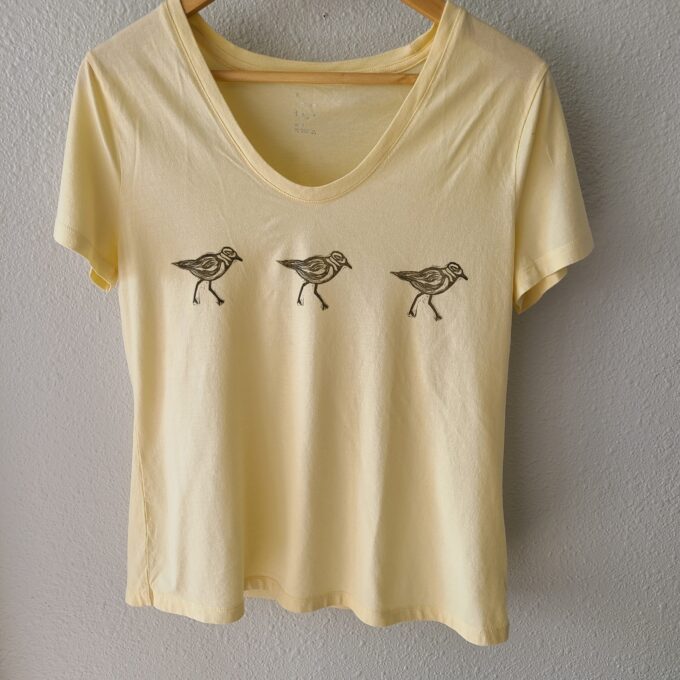 a yellow shirt with three birds on it.