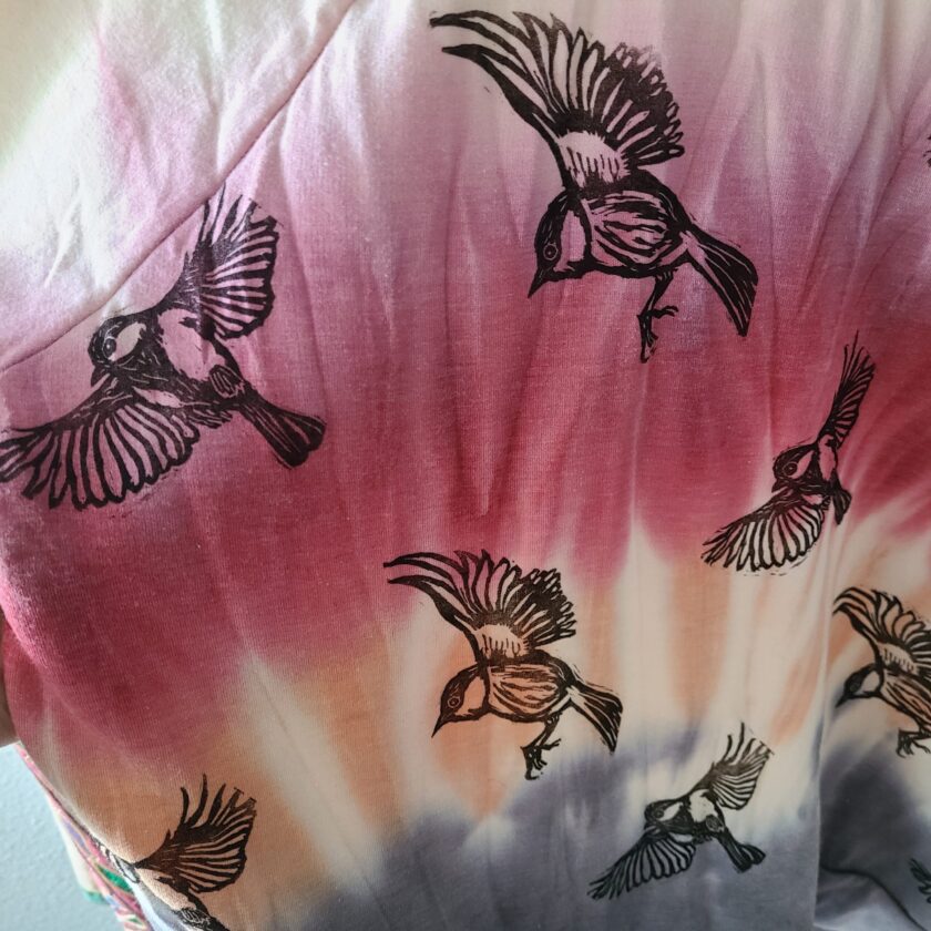 a tie dye shirt with birds on it.