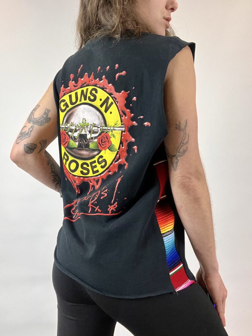 a woman wearing a tank top with a guns n roses design on it.