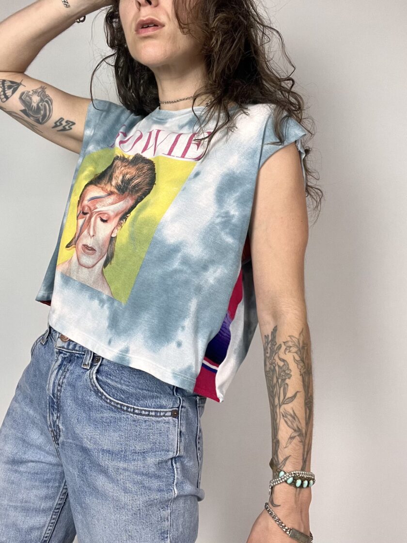 a woman wearing a tie dye shirt with a picture of a man on it.
