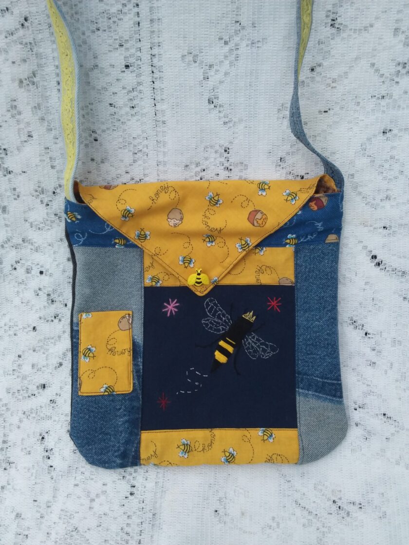 Bee Charmer handbag with upcycled denim and vintage honey bee fabric has a hand embroidered queen bee and whimsical bee button accent