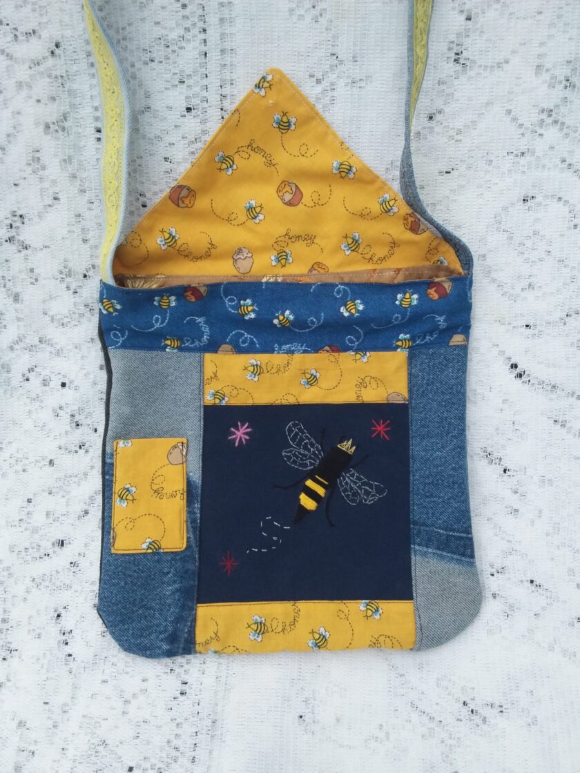 Bee Charmer handbag with upcycled denim and vintage honey bee fabric has a hand embroidered queen bee and whimsical bee button accent