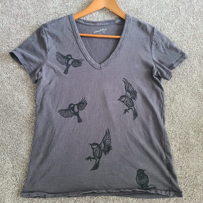 a gray v - neck t - shirt with birds on it.