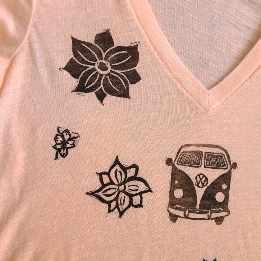 a vw bus and flowers on a pink t - shirt.