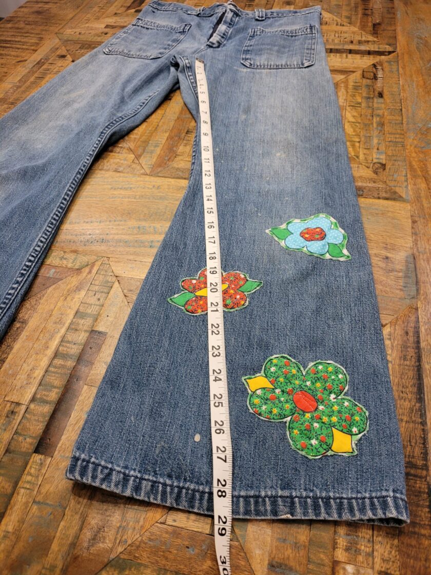 a pair of jeans with flowers on them.