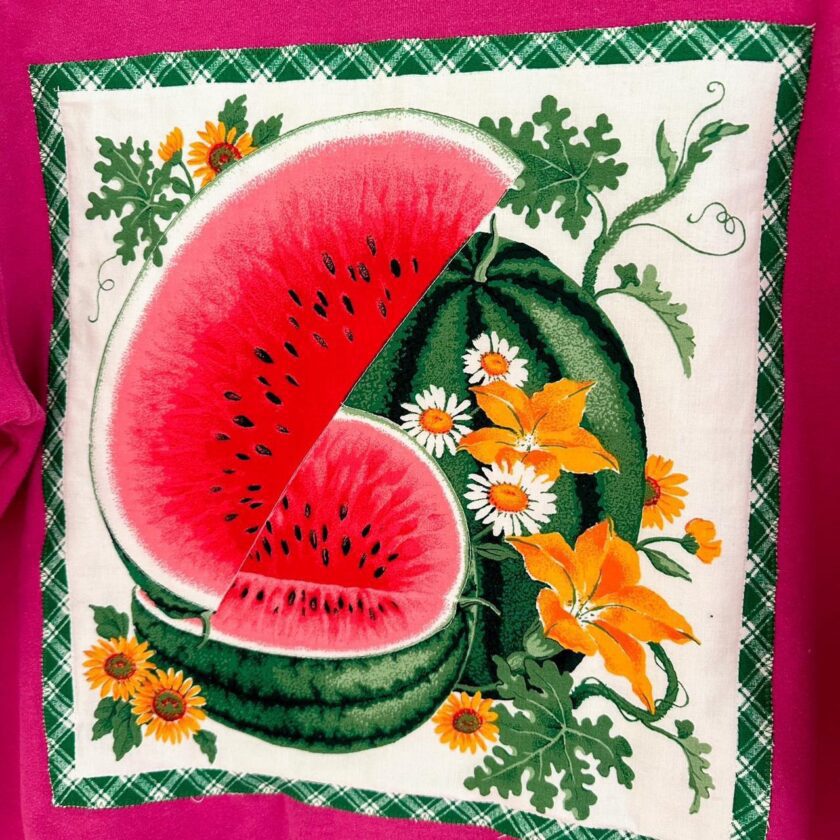 a pink pillow with a watermelon and daisies on it.