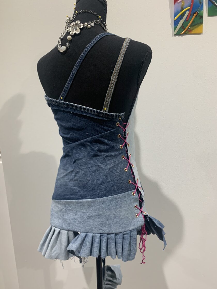 a mannequin wearing a denim dress with ruffles.