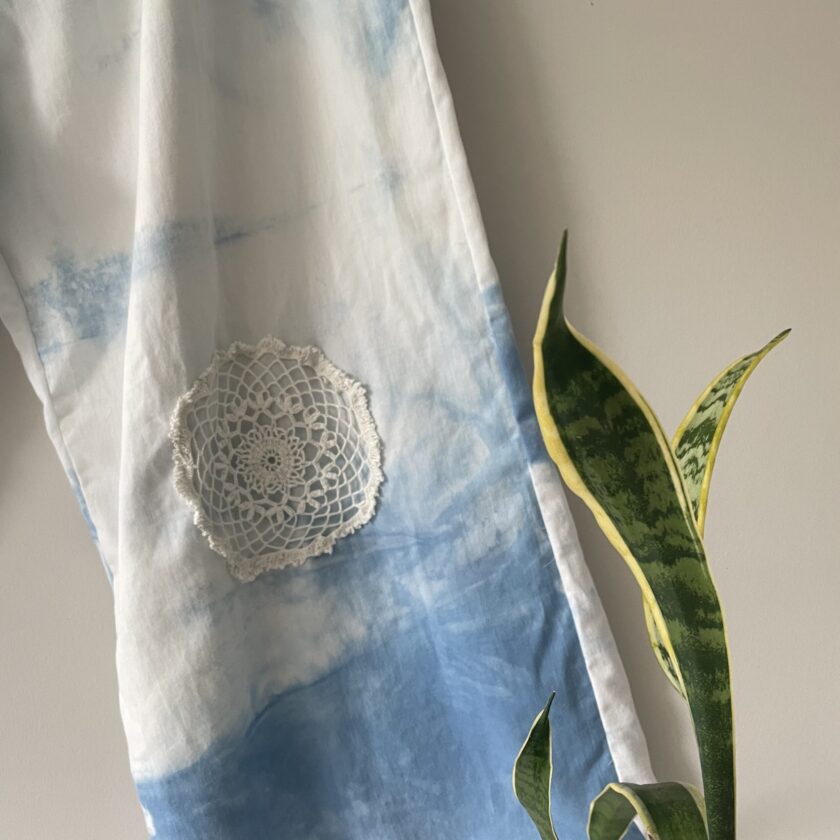 A blue and white tie dyed kimono with a crocheted flower.