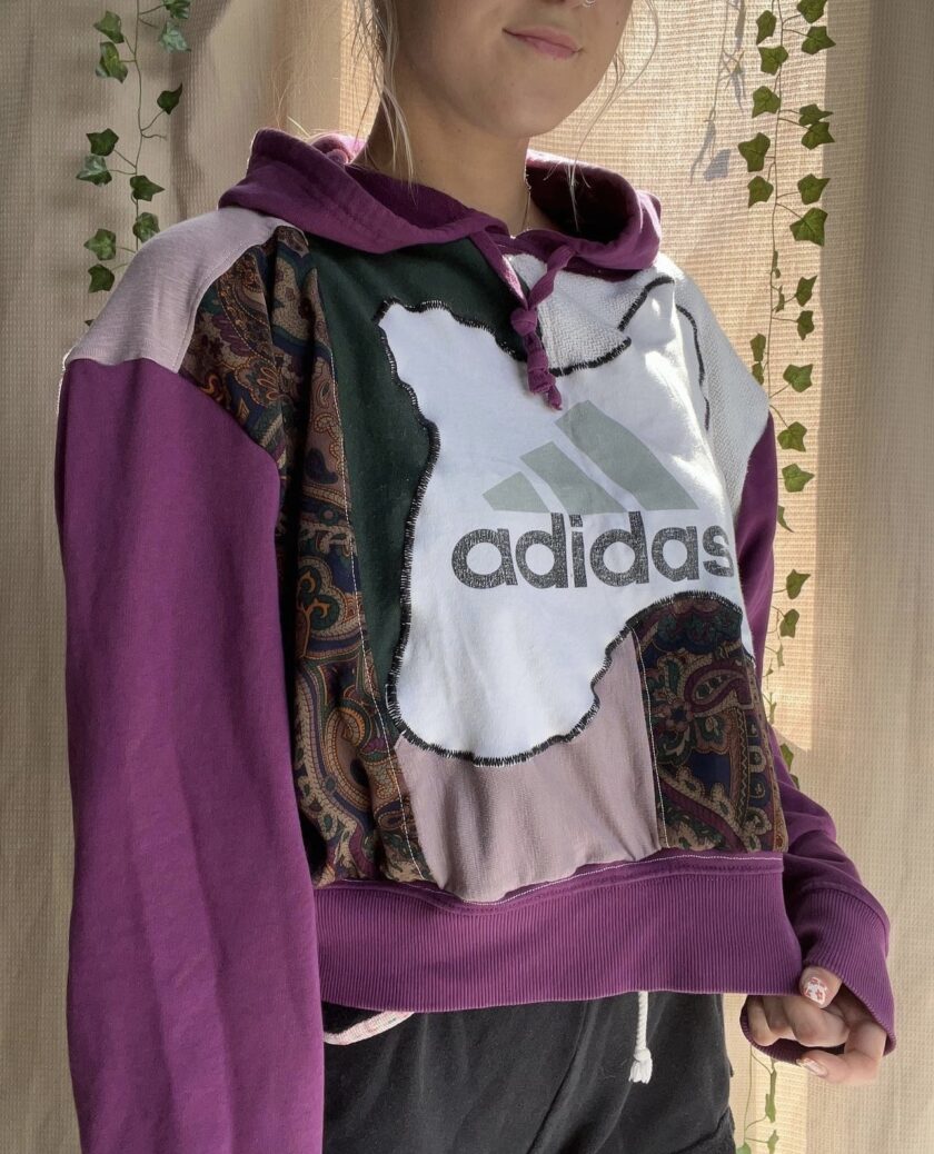 A woman wearing an adidas cropped hoodie.