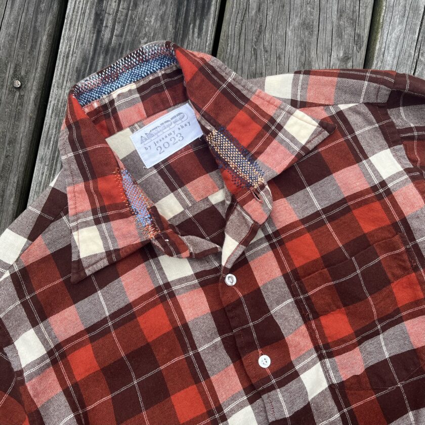 A red and white plaid shirt on a wooden deck.