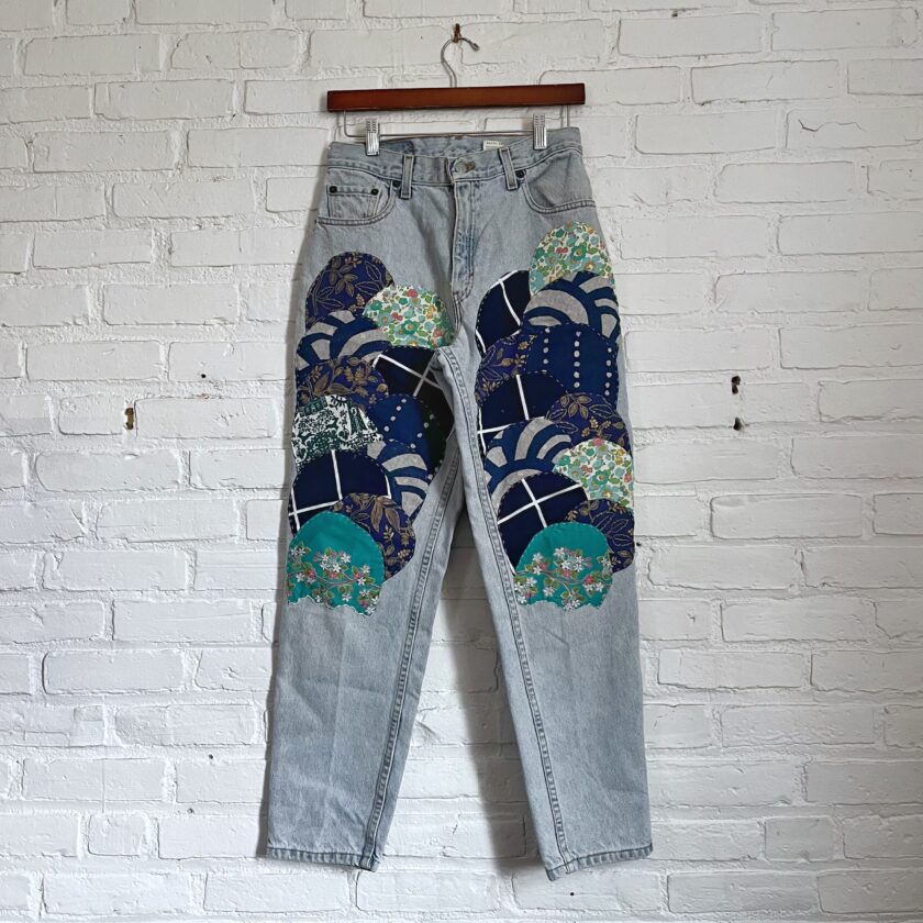 A pair of blue jeans with embroidered flowers on them.