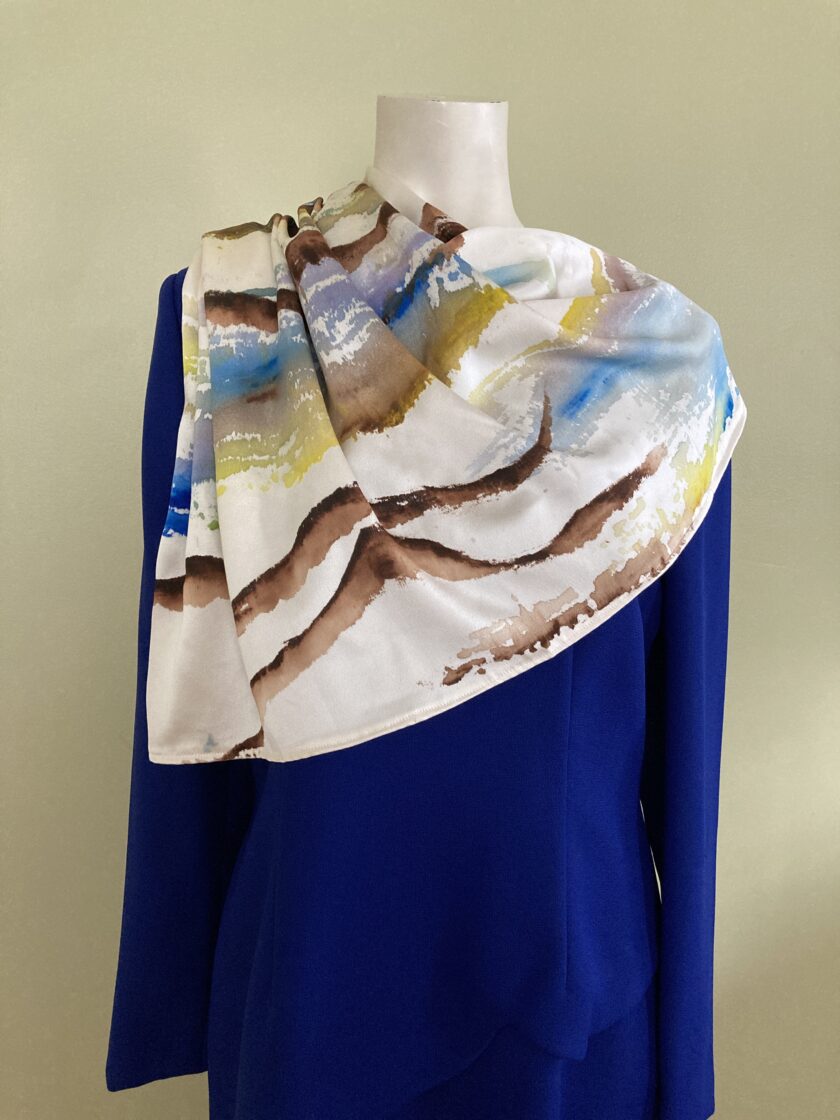 A hand-painted upcycled silk scarf worn with a blue dress
