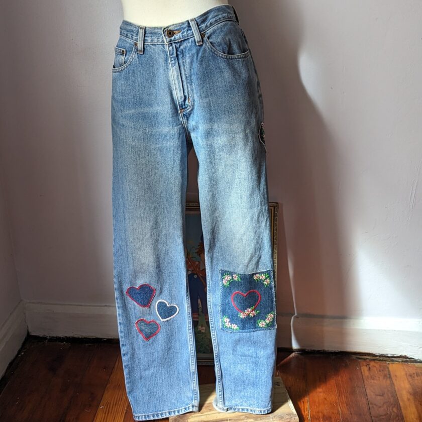 A pair of blue jeans with hearts on them.
