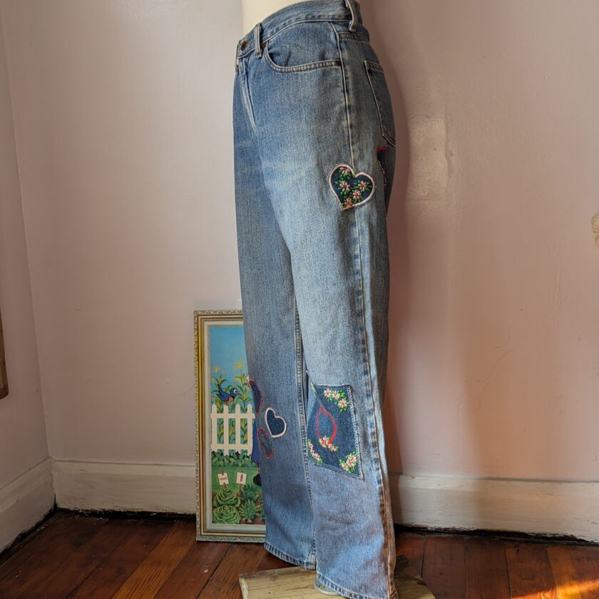 A mannequin wearing a pair of jeans with embroidered hearts.