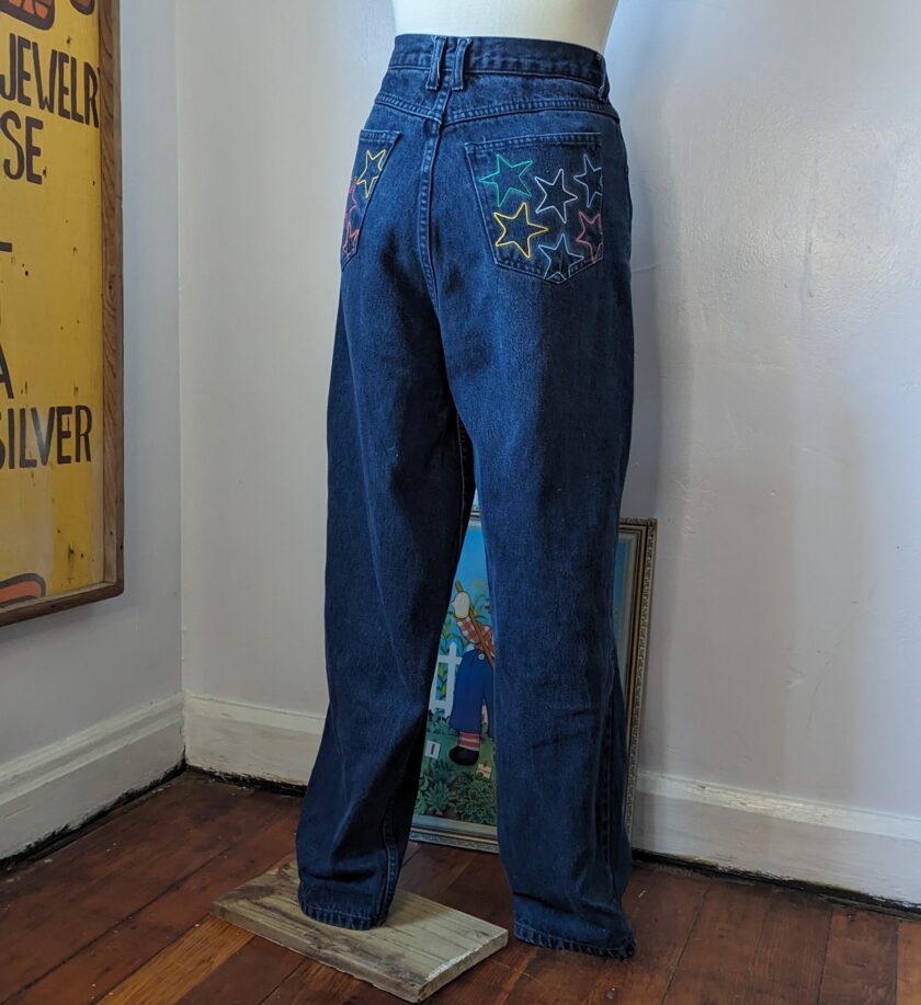 A mannequin wearing a pair of jeans with embroidered stars.