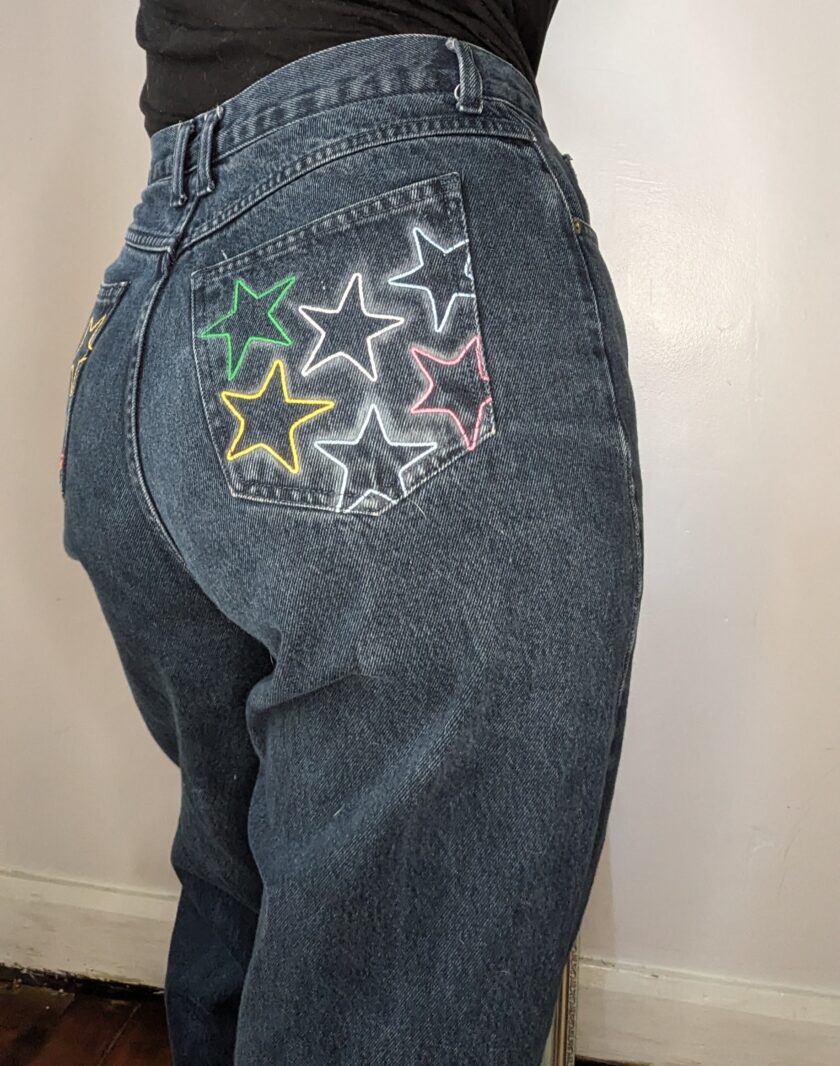 A woman wearing a pair of jeans with stars painted on them.