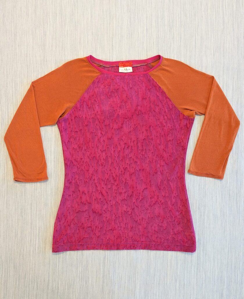A women's top with a pink and orange sleeve.