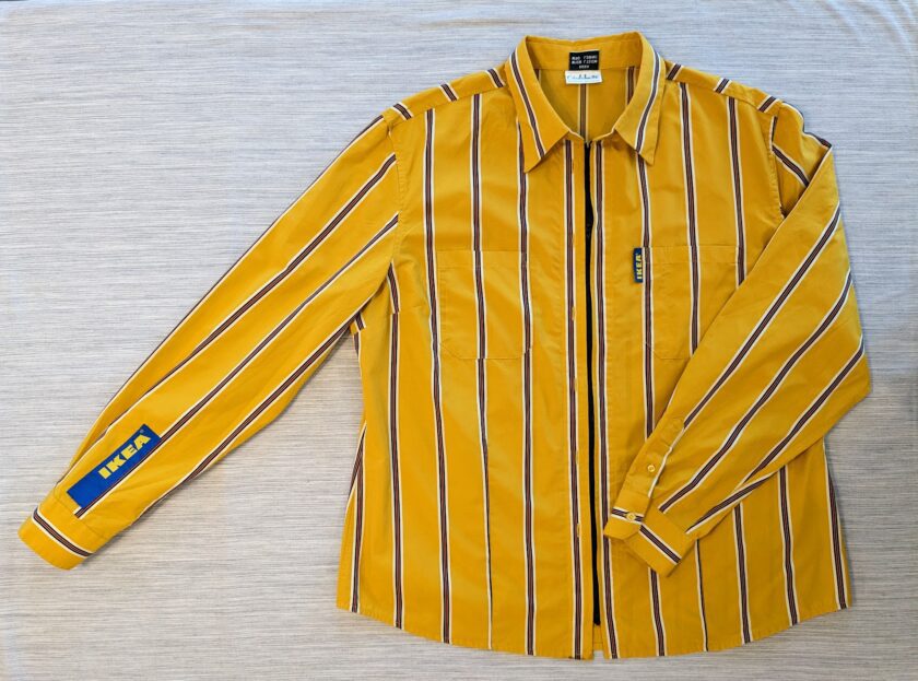 A yellow and blue striped shirt on a bed.
