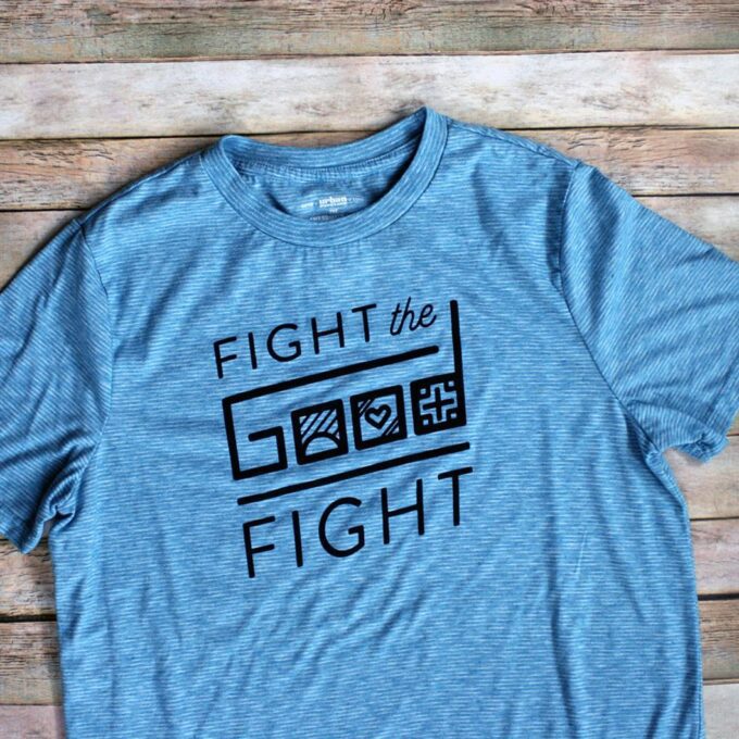 A blue t - shirt that says fight the good fight.