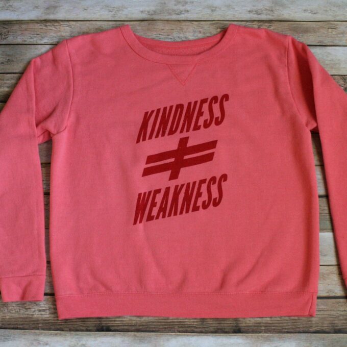 A pink sweatshirt with the words kindness and weakness on it.