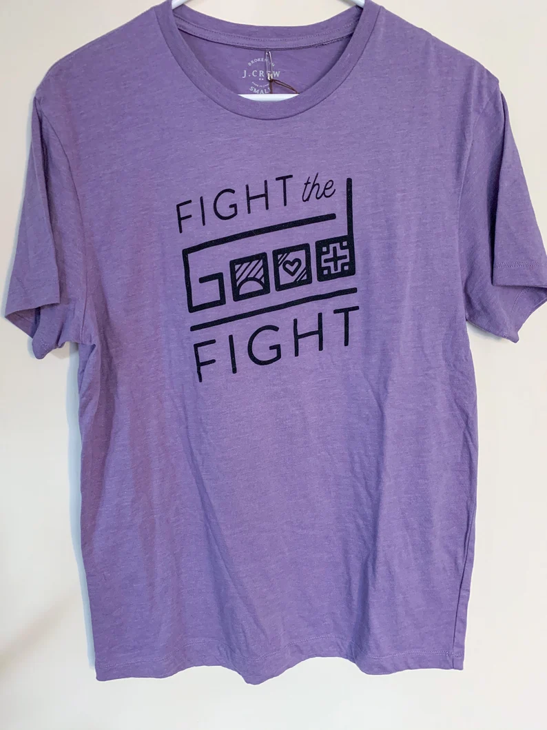 A purple t - shirt that says fight the good fight.