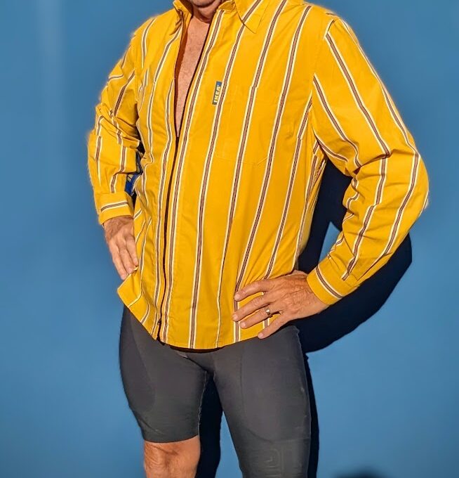 A man wearing a yellow striped shirt and shorts.