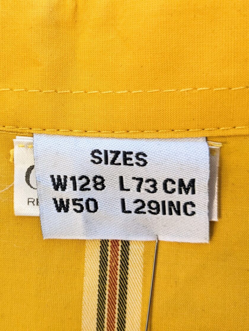 A label on a yellow shirt with a number on it.