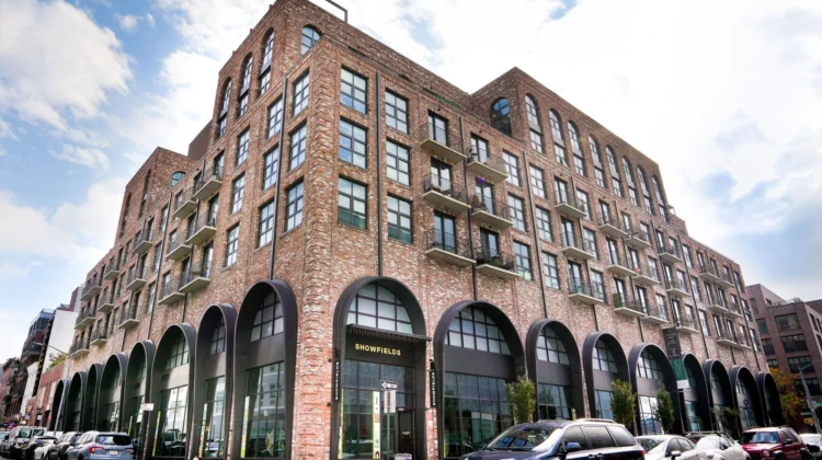 A large brick building with cars parked in front of it.