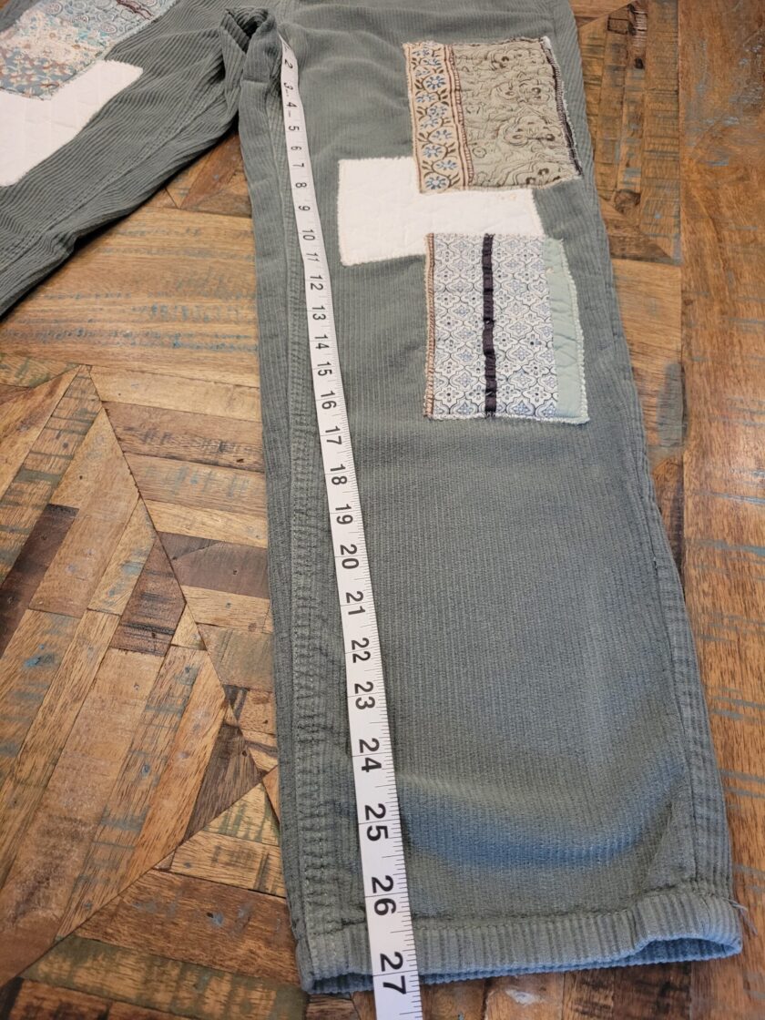 A pair of pants with patches and a tape measure.