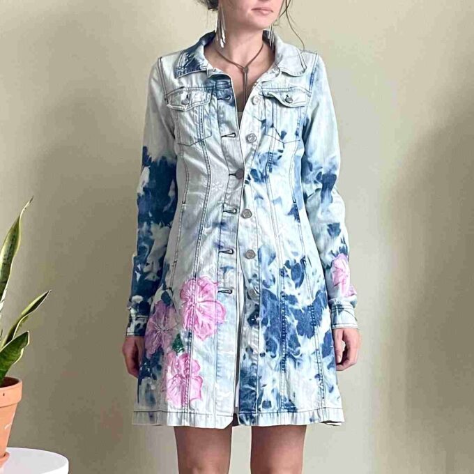 A woman wearing a denim dress with flowers on it.