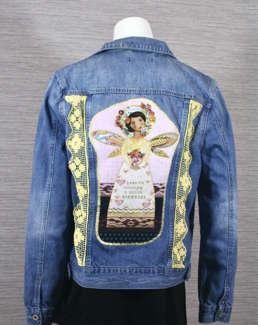 A denim jacket with an image of an angel on it.