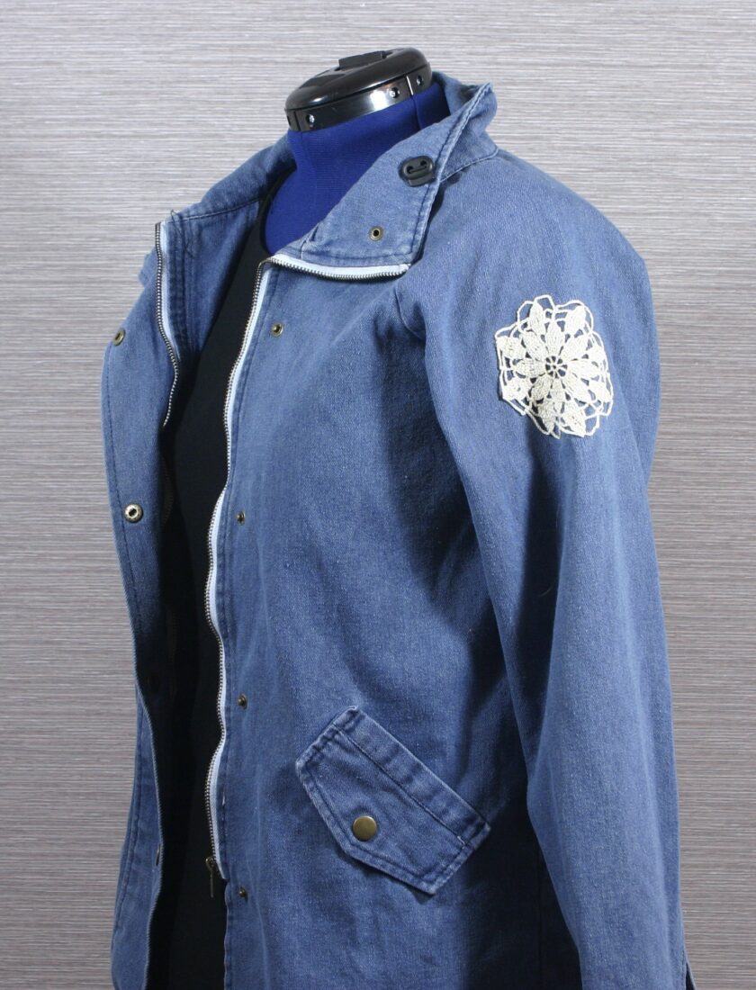 A blue denim jacket with a flower on it.