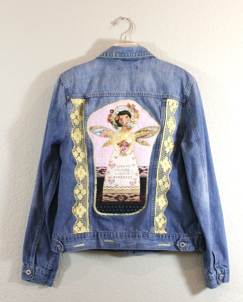 A denim jacket with an angel on it.