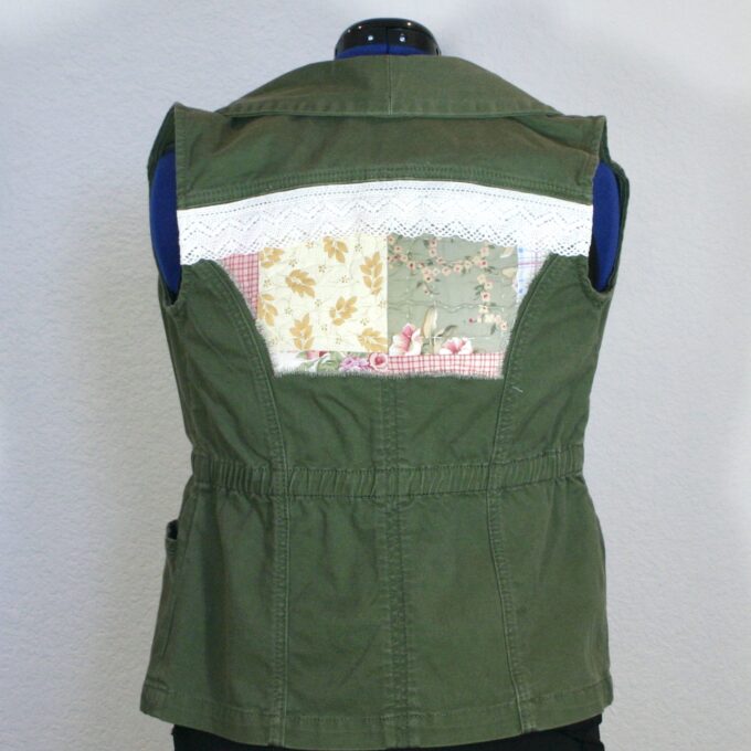 A green vest with patchwork on the back.