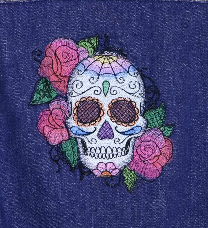 A blue denim shirt with a sugar skull and roses embroidered on it.