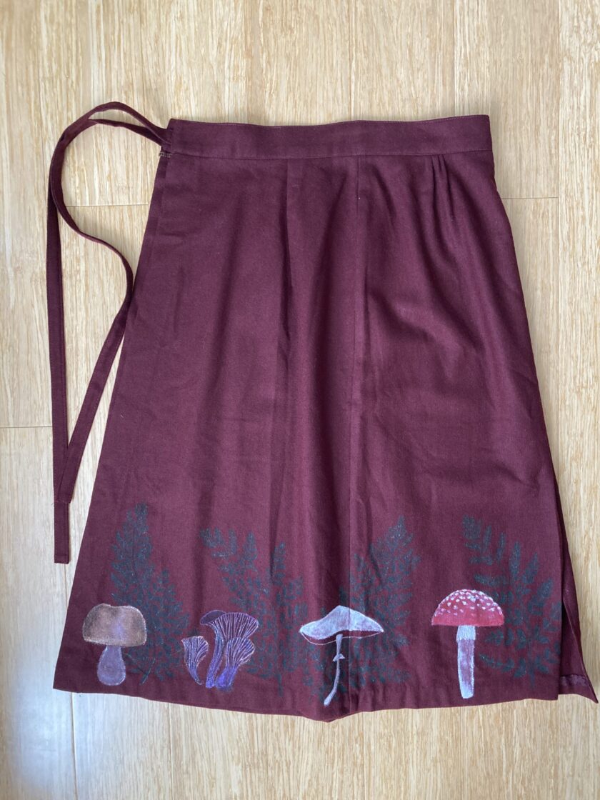 A burgundy skirt with mushrooms on it.