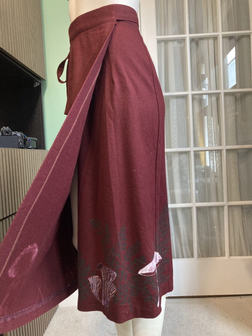 A mannequin wearing a burgundy skirt.