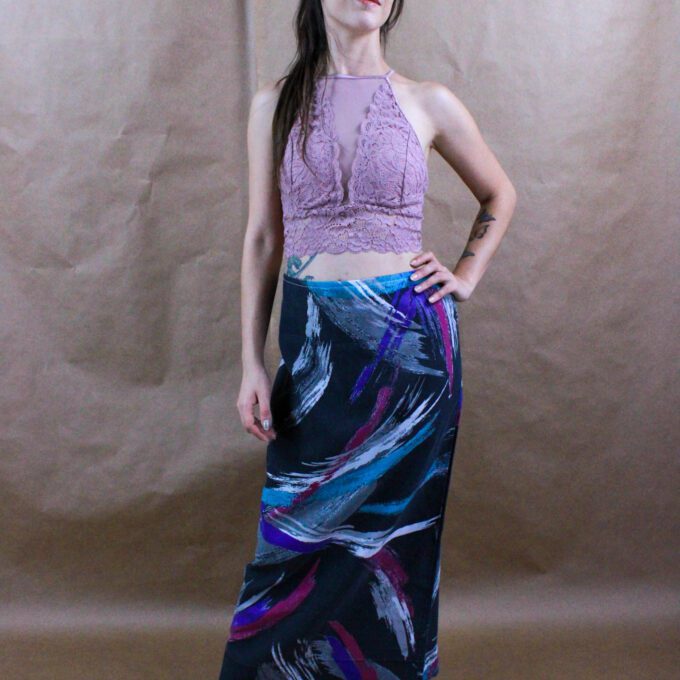 A woman is posing for a picture wearing a long skirt.