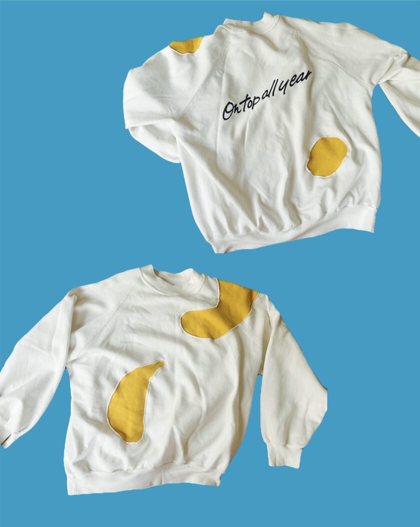 A white sweatshirt with a yellow detail