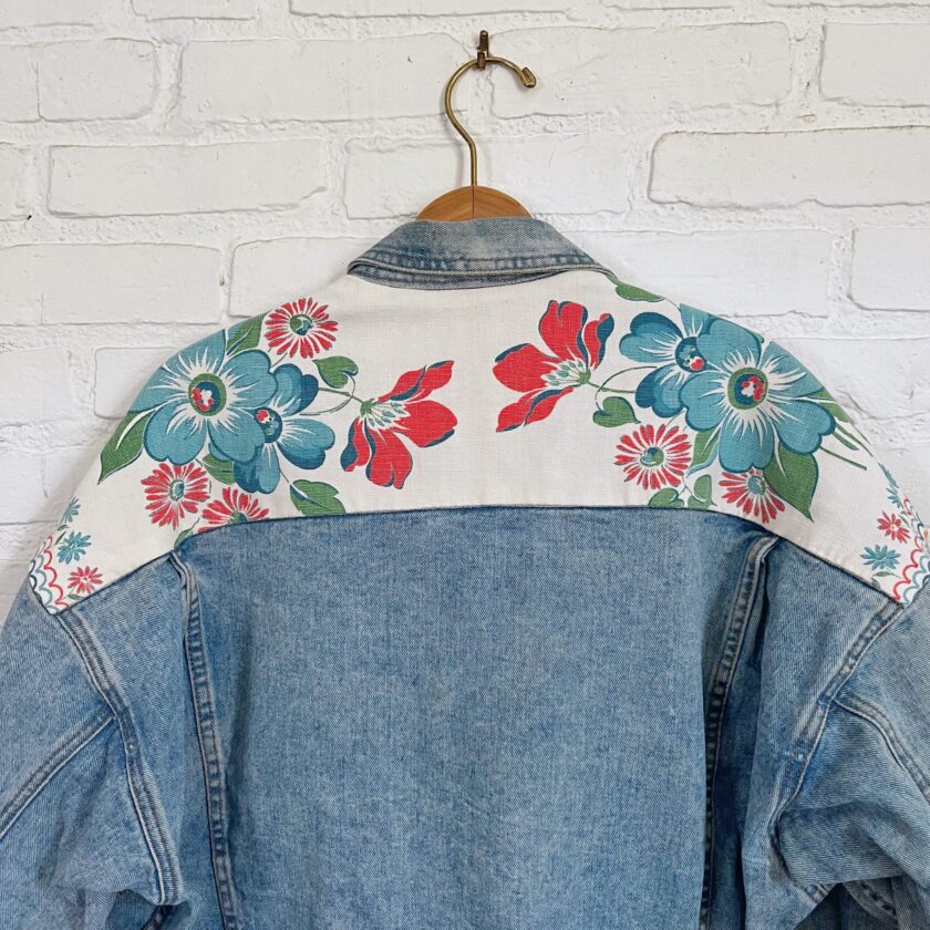 A denim jacket with flowers on it.